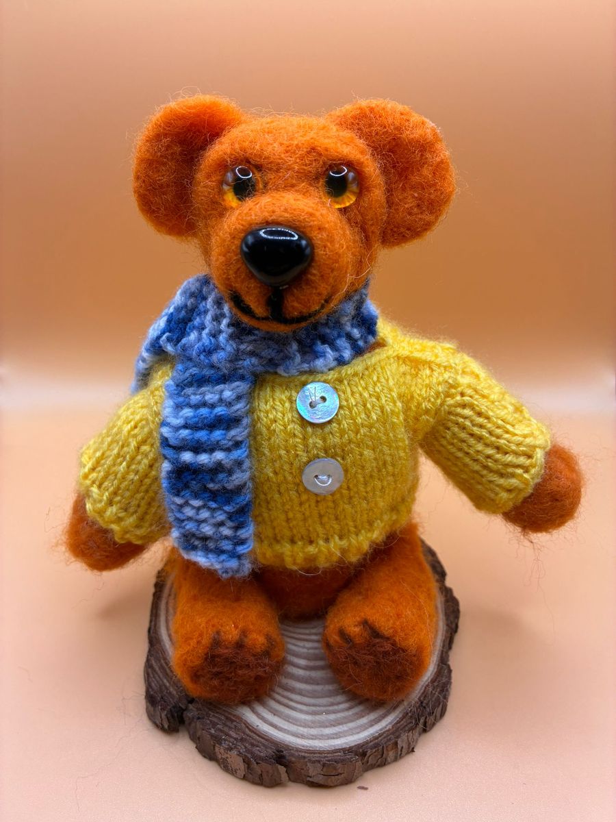 Needle felt bear in yellow jumper on wood slice