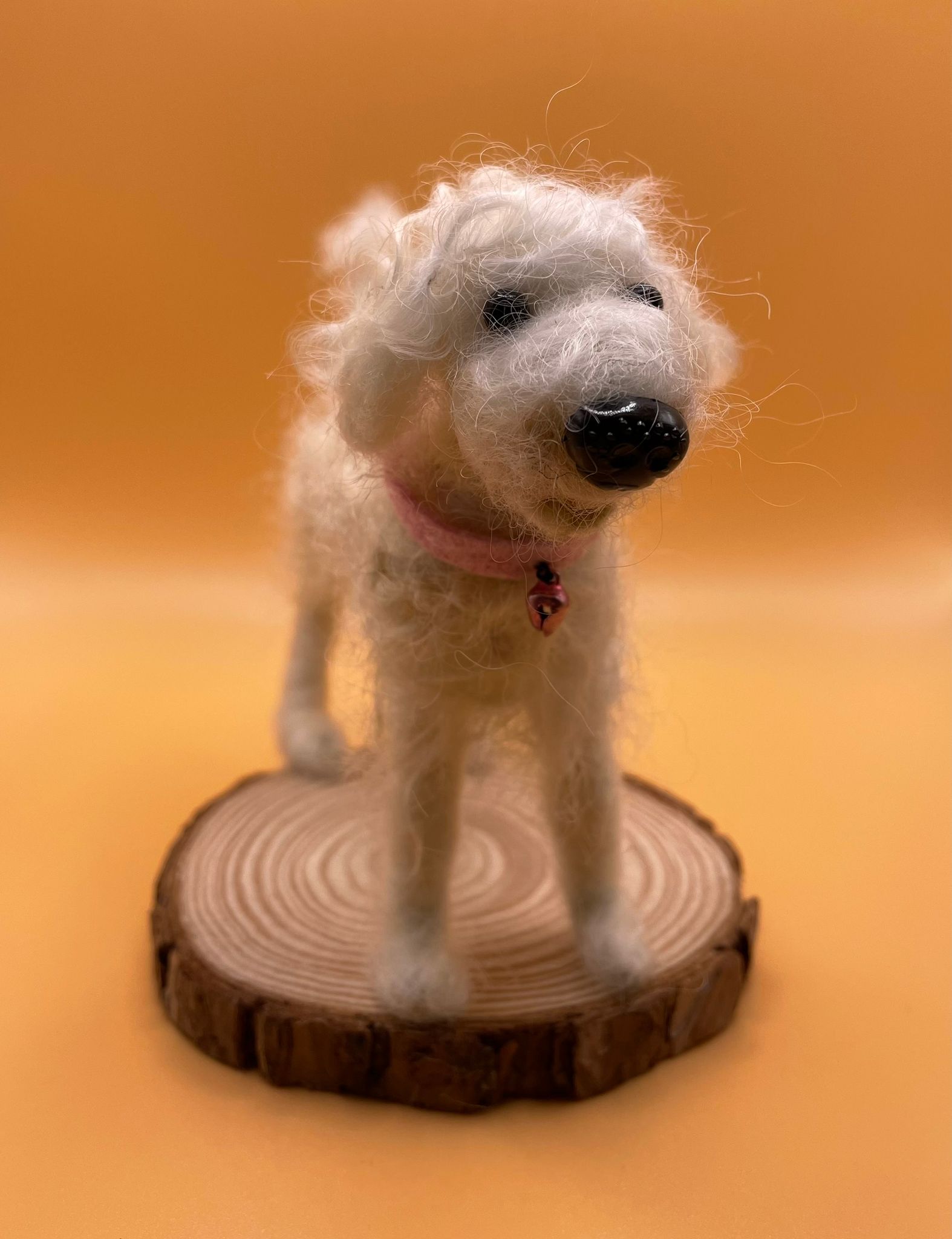 Needle felt white fluffy dog on wood slice