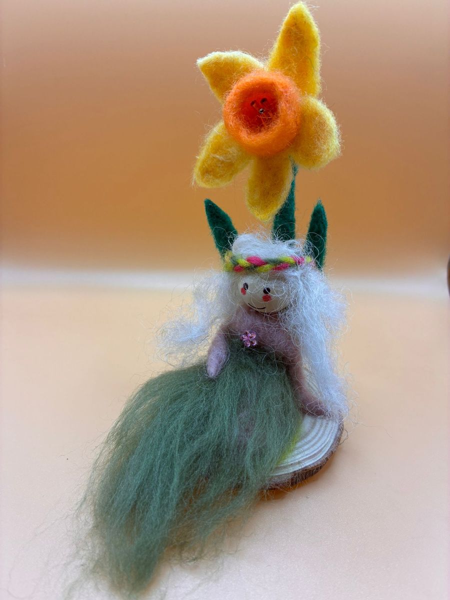 Needle felt fairy with daffodil on wood slice