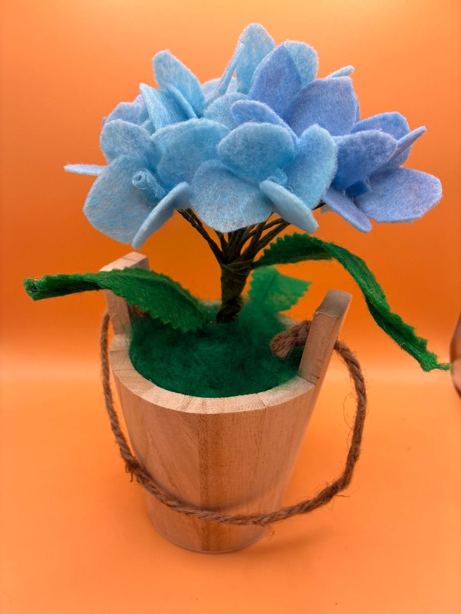 Felt blue hydrangea in wooden bucket