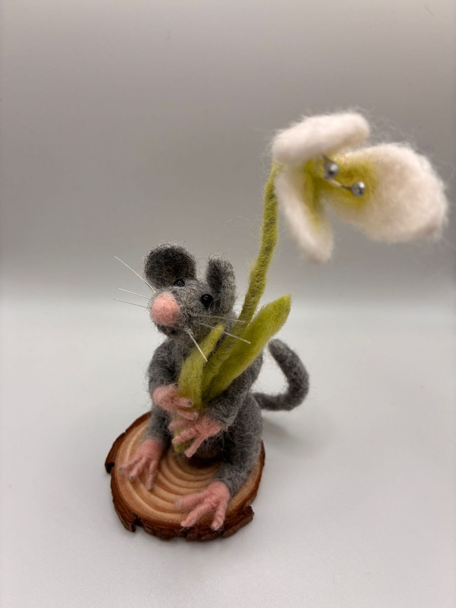 Needle felt mouse holding a snowdrop on wood slice
