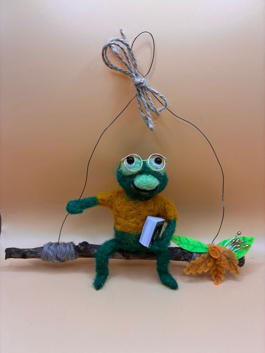 Needle felt frog with glasses and book on hanging twig