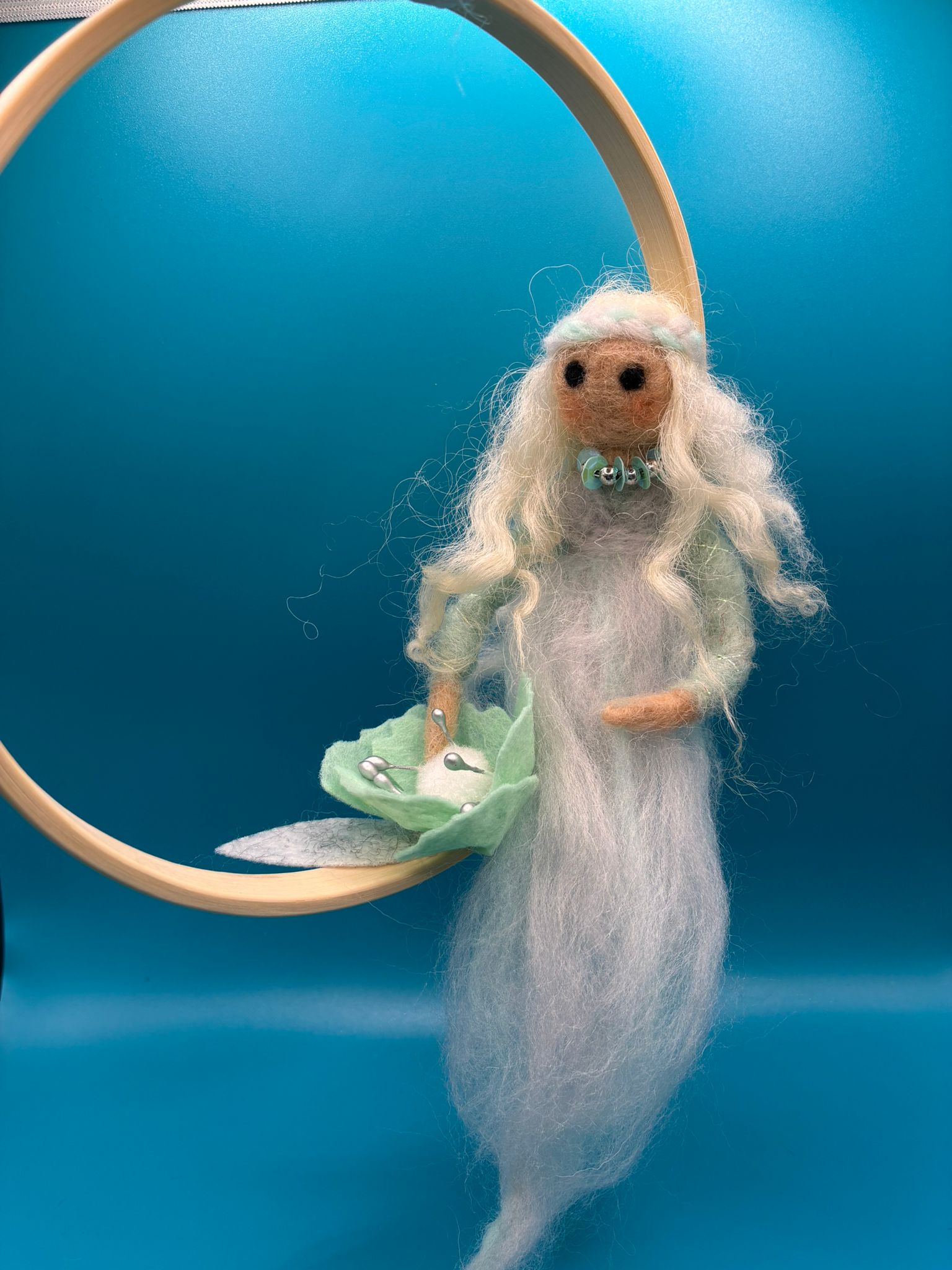 Needle felt white fairy seated on wooden embroidery hoop